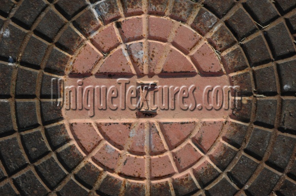 manhole pattern shadow textual weathered industrial metal multicolored orange/peach       