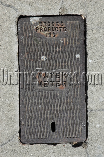 door street manhole rectangular diamonds textual rusty industrial metal concrete dark brown gray