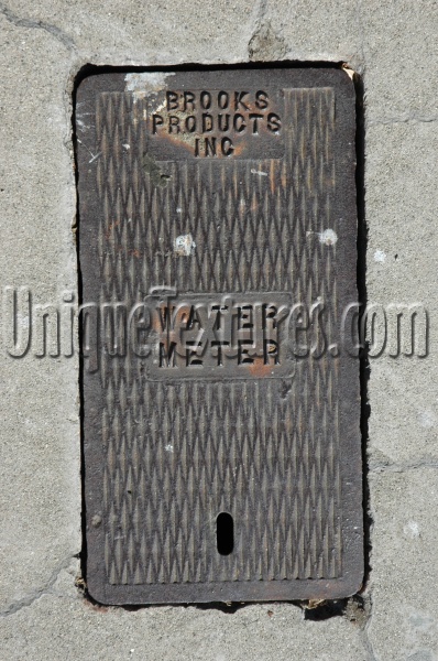 door street manhole rectangular diamonds textual rusty industrial metal concrete dark brown gray