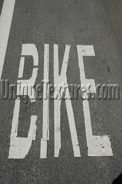 gray white paint asphalt industrial vehicle textual oblique street