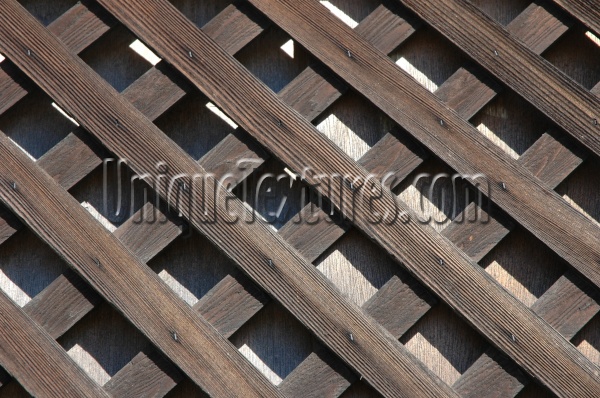 slats fence angled diamonds pattern shadow weathered architectural wood dark brown