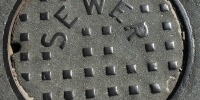 street manhole square round textual shiny industrial asphalt metal metallic gray