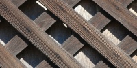 slats fence angled diamonds pattern shadow weathered architectural wood dark brown